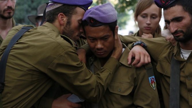 Credit: Siegfried Modola/Reuters. Israeli soldiers mourn during the funeral of their comrade Lt. Hadar Goldin in Kfar Saba, near Tel Aviv, on August 3, 2014. Goldin's death in Gaza is prompting some in Israel to question their military's controversial Hannibal Doctrine.
