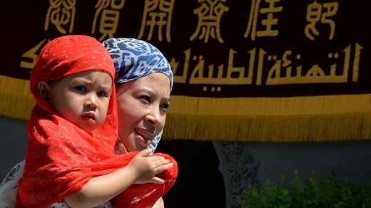 CHINE_Une Hui tient sa fille dans ses bras à Pékin, devant la mosquée de Nijuie. La population musulman en Chine est estimée à 40 milliions.Mark Ralston. AFP