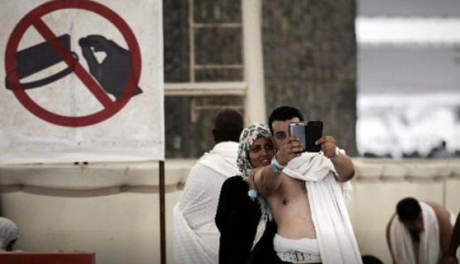 Des pèlerins musulmans prennent un selfie pendant le rituel de la lapidation à Mina, près de La Mecque, le 4 octobre 2014 (c) Afp