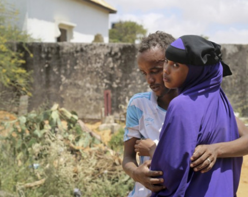 Zakariye Abdirisaq, à gauche, dont le père et la tante faisaient partie des centaines de personnes tuées dans l'attentat à la voiture piégée de Mogadiscio, est réconforté par sa cousine. Photographie par Mohamed Sheikh Nor / AP