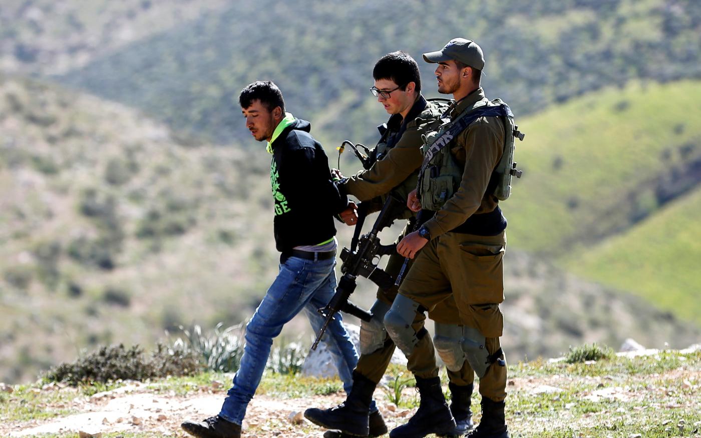 Des soldats israéliens arrêtent un Palestinien lors de la démolition de sa maison, pour laquelle il n’aurait pas obtenu de permis de construire, près de Yatta, en Cisjordanie occupée (Reuters)